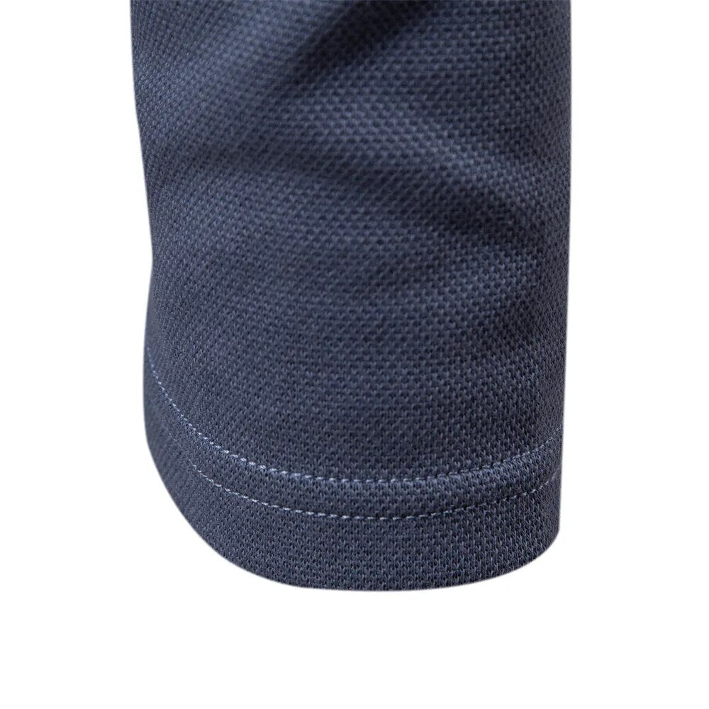 Man draagt een stijlvol grijs heren poloshirt met lange mouwen, benadrukkend de casual look.