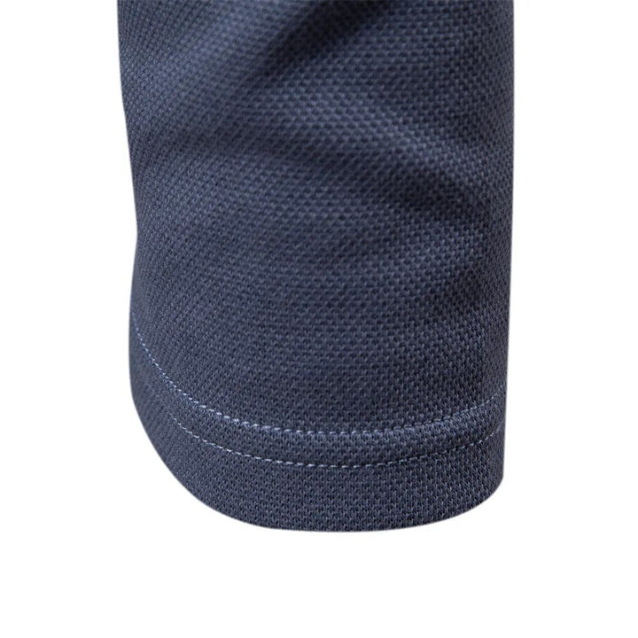 Man draagt een stijlvol grijs heren poloshirt met lange mouwen, benadrukkend de casual look.