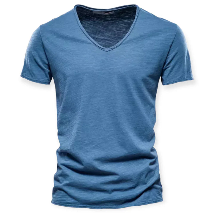 Model combineert een wit heren v-hals T-shirt met jeans, benadrukt de relaxte en moderne stijl.