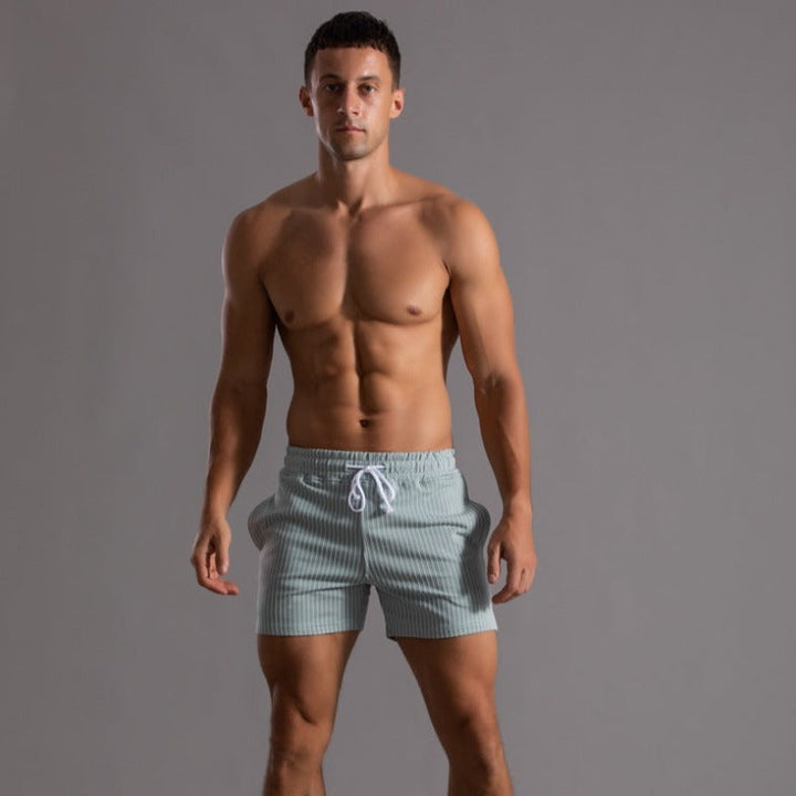 Model draagt ademende heren fitness shorts, geschikt als hardloopshorts.