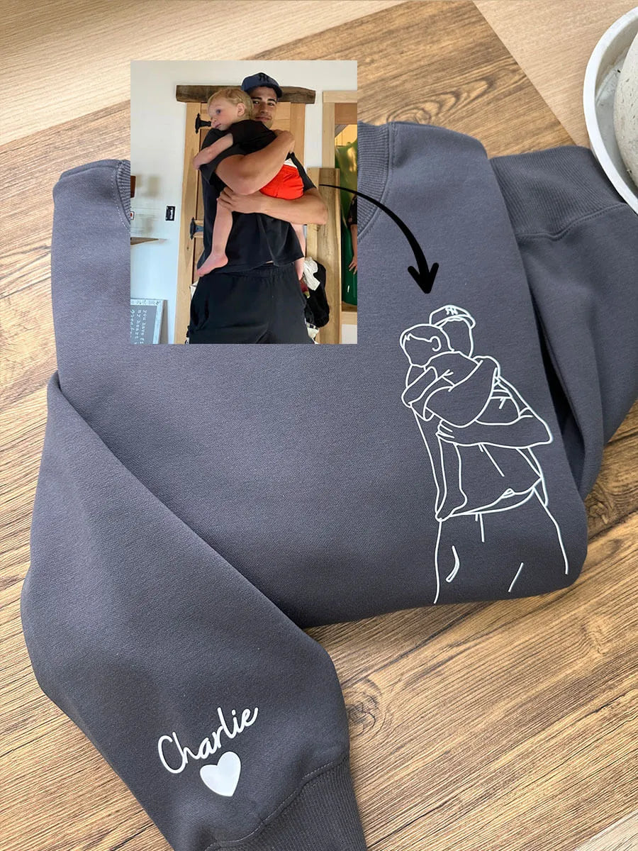 Close-up van geborduurd lijnkunst portret op een grijze gepersonaliseerde heren hoodie, emotioneel uniek cadeau.