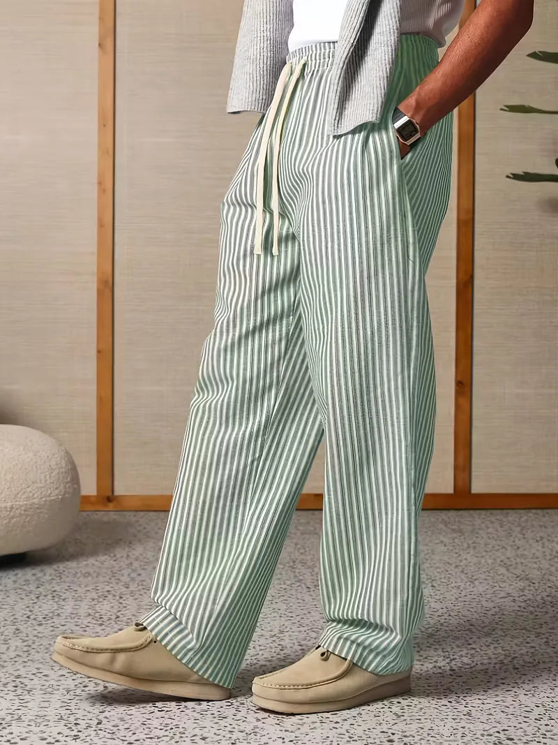Man in gestreepte joggers in beweging, toont de flexibiliteit en comfortabele wijde fit. Casual heren broek.