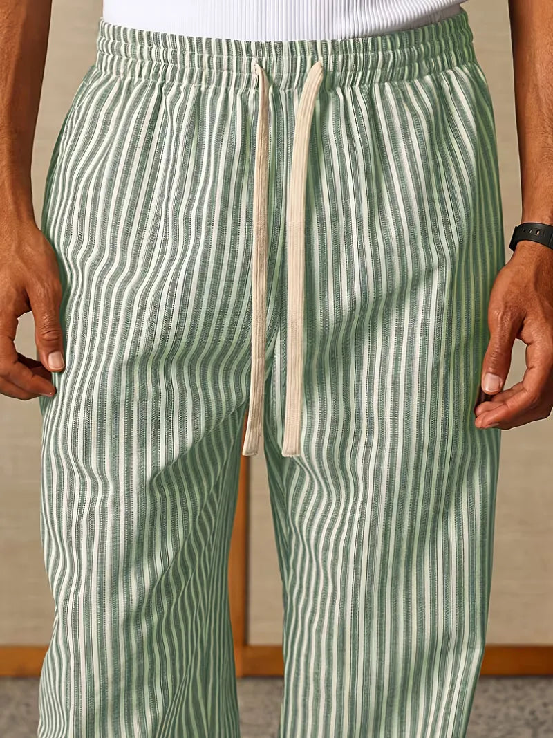 Heren gestreepte joggers gecombineerd met casual sneakers. Ontspannen lente/zomer look met comfortabele broek.