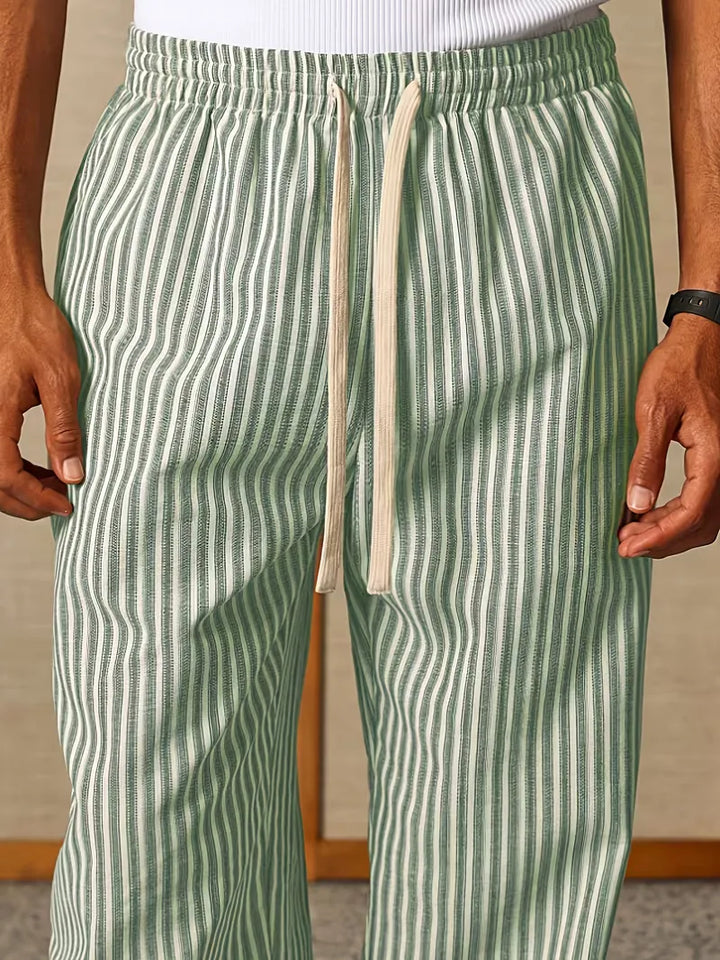 Heren gestreepte joggers gecombineerd met casual sneakers. Ontspannen lente/zomer look met comfortabele broek.
