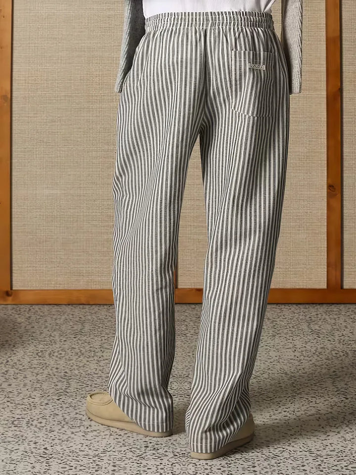 Zijaanzicht van een man in wijde fit gestreepte heren joggers. Mid-rise, perfect voor relaxte lounge outfits.