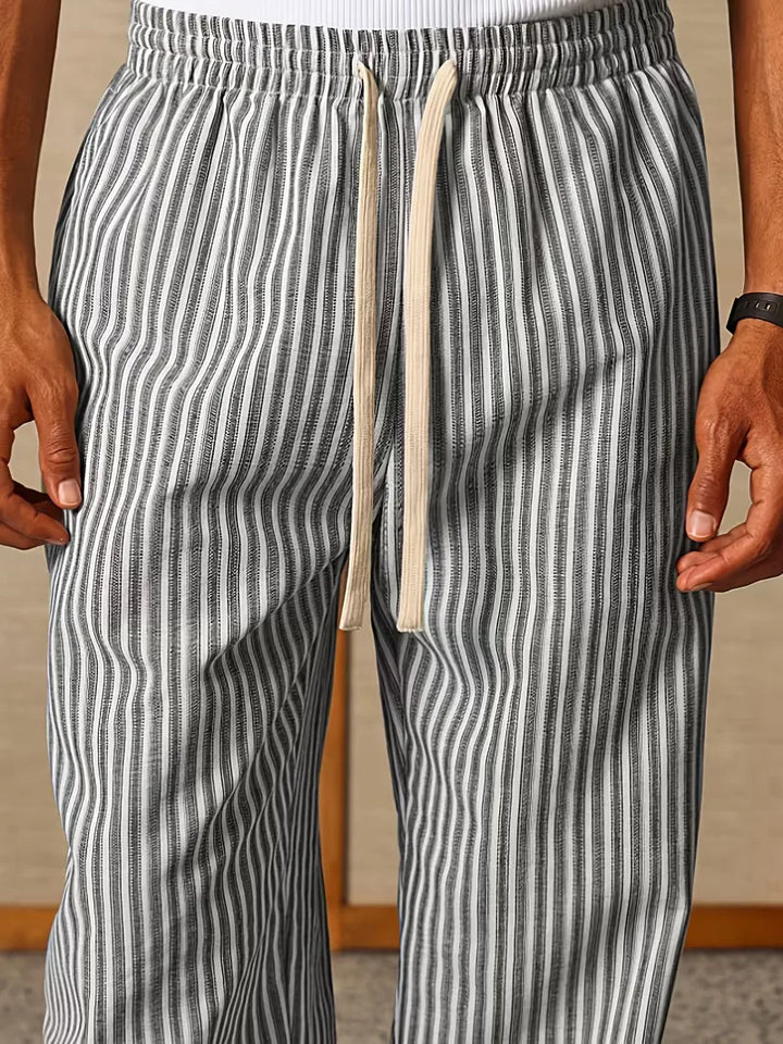 Achterkant van gestreepte heren joggers gedragen door model. Casual broek voor lente & zomer comfort.
