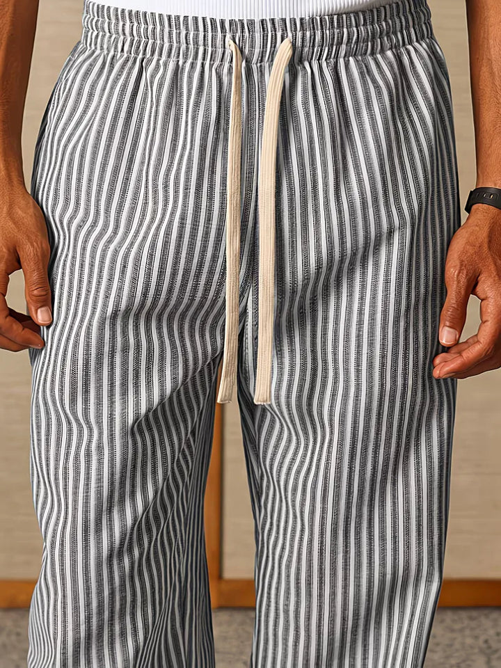 Detail van de elastische tailleband van de gestreepte heren joggers. Zorgt voor comfortabele mid-rise fit.