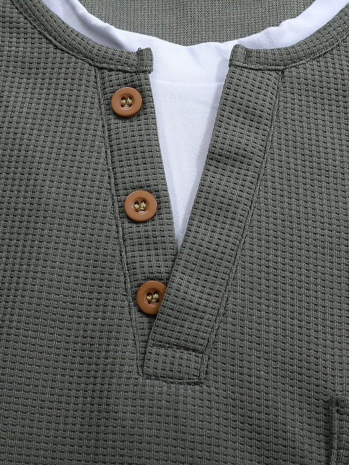 Close-up van het heren henley shirt met lange mouwen, detail van de knoopsluiting en zachte stofstructuur.
