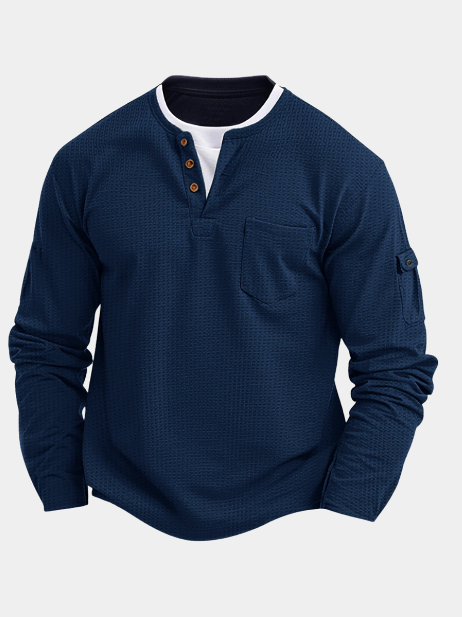 Man draagt casual heren henley shirt met lange mouwen, knoopsluiting en borstzak, voor een relaxte stijl.