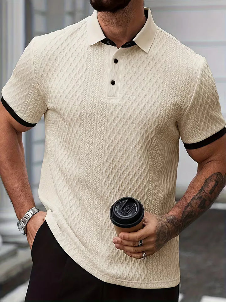 Detailopname van de jacquard textuur en de V-hals op dit herenpoloshirt.