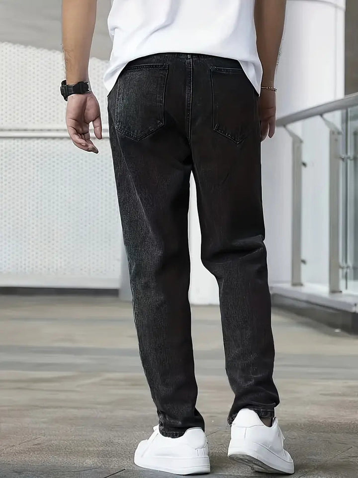 Man draagt stijlvolle heren jeans met rechte pijpen, lichte wassing, perfect voor een dagelijkse outfit.