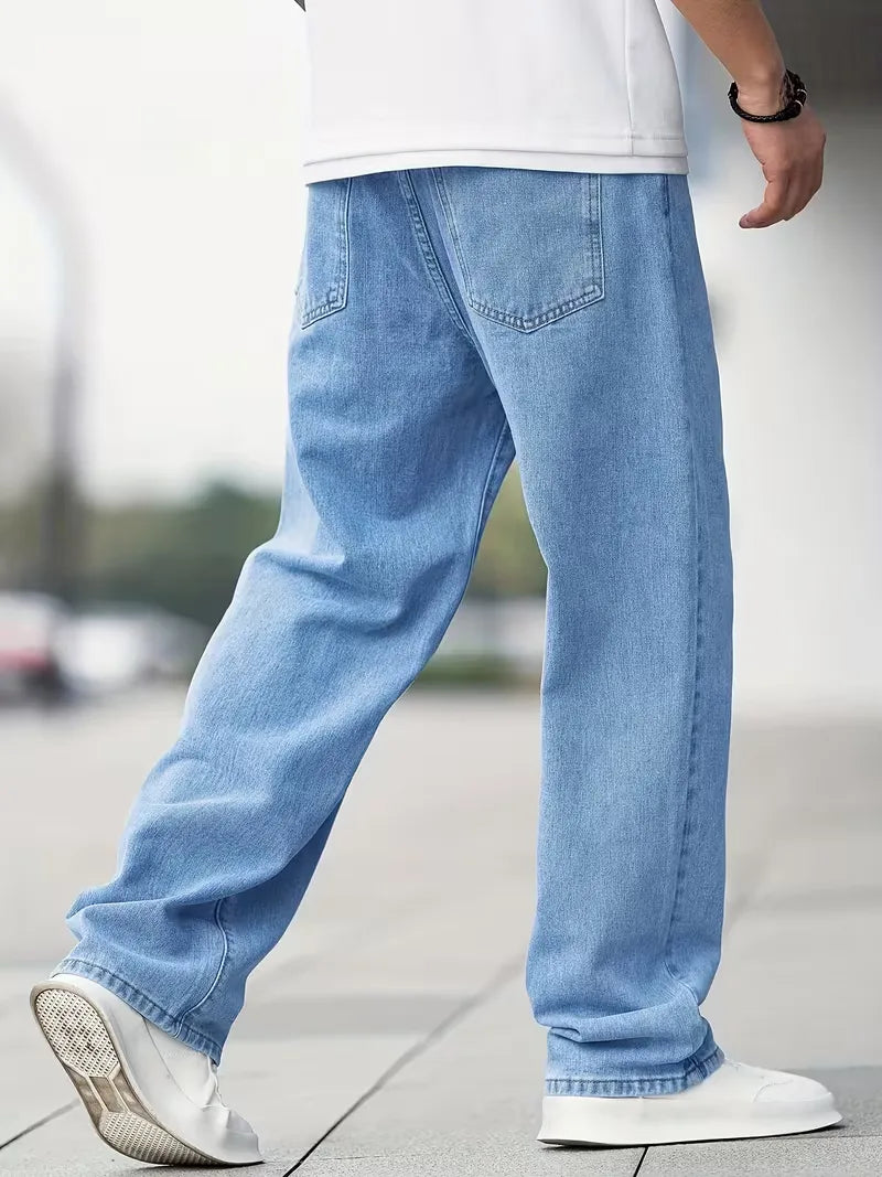 Model draagt comfortabele heren lichtblauwe straight jeans met mid-rise pasvorm, een essentiële broek.