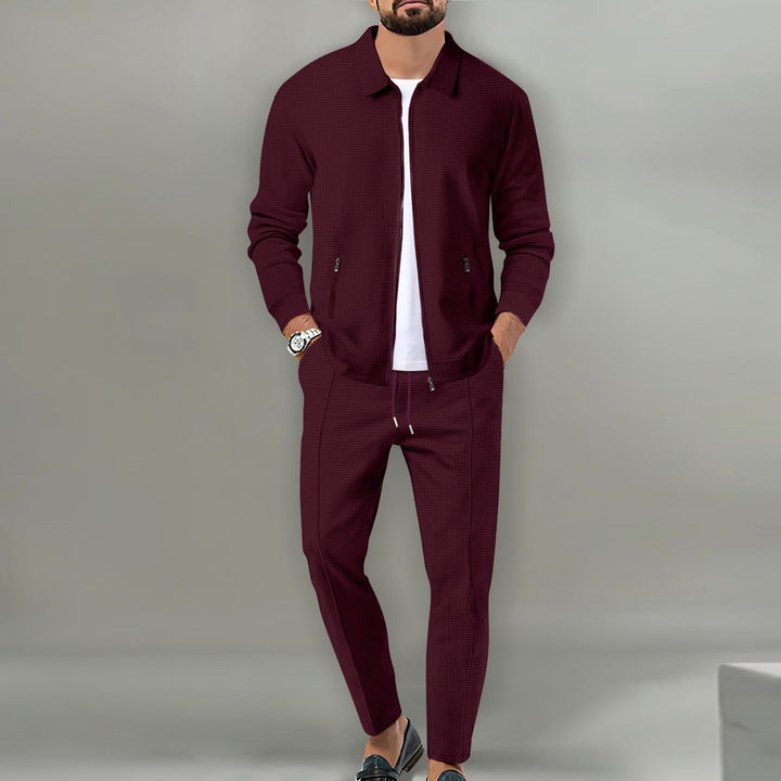 Man draagt comfortabel heren sportpak: lichtgewicht tracksuit met jas en joggingbroek, ideaal voor vrije tijd of training.