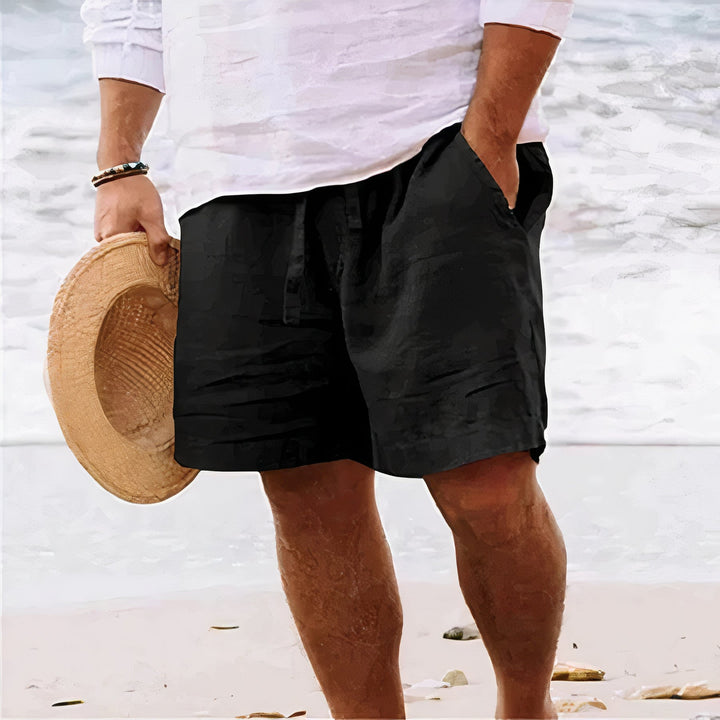 Man draagt een witte linnen short en een T-shirt, perfecte ademende zomerkleding voor heren.