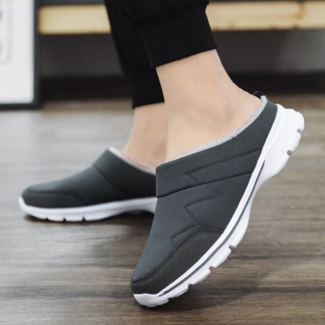 Zwarte fleece herenpantoffels met orthopedische ondersteuning, ideaal voor koude dagen thuis.