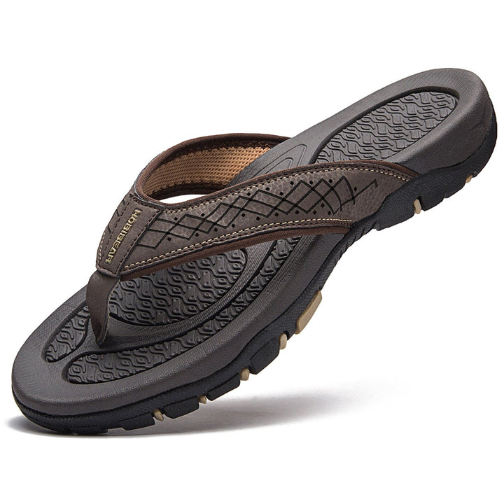 Herenslippers, zwart, op een strand, voor optimaal voetcomfort.