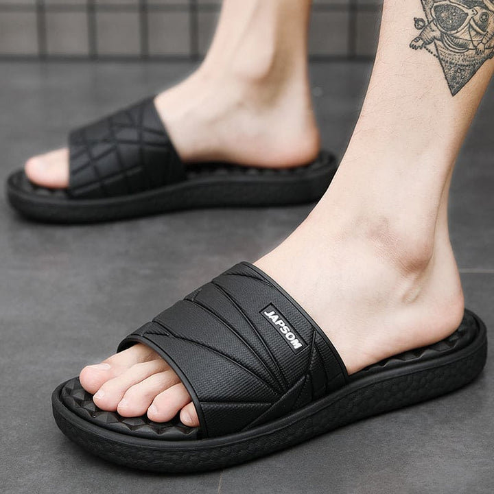 Man zit op een stoel met comfortabele orthopedische slippers aan, leesboek op schoot.