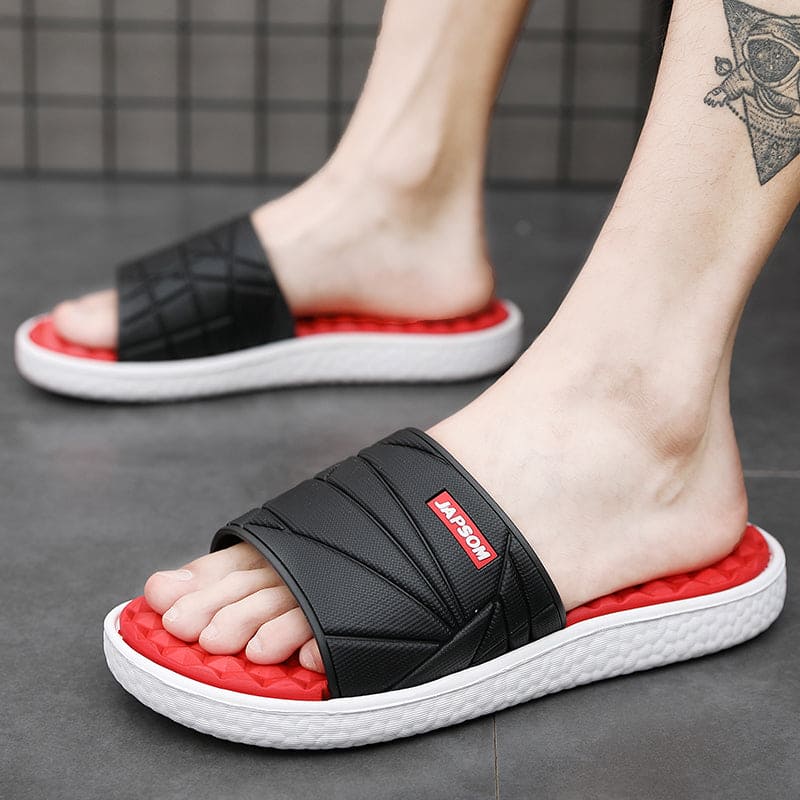 Zwarte orthopedische herenslippers met subtiel logo, modern en bevorderlijk voor voetgezondheid.
