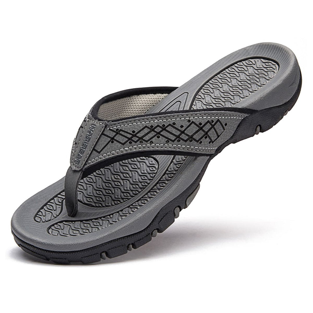 Bovenaanzicht van grijze herenslippers met orthopedische steun, casual en modieus.