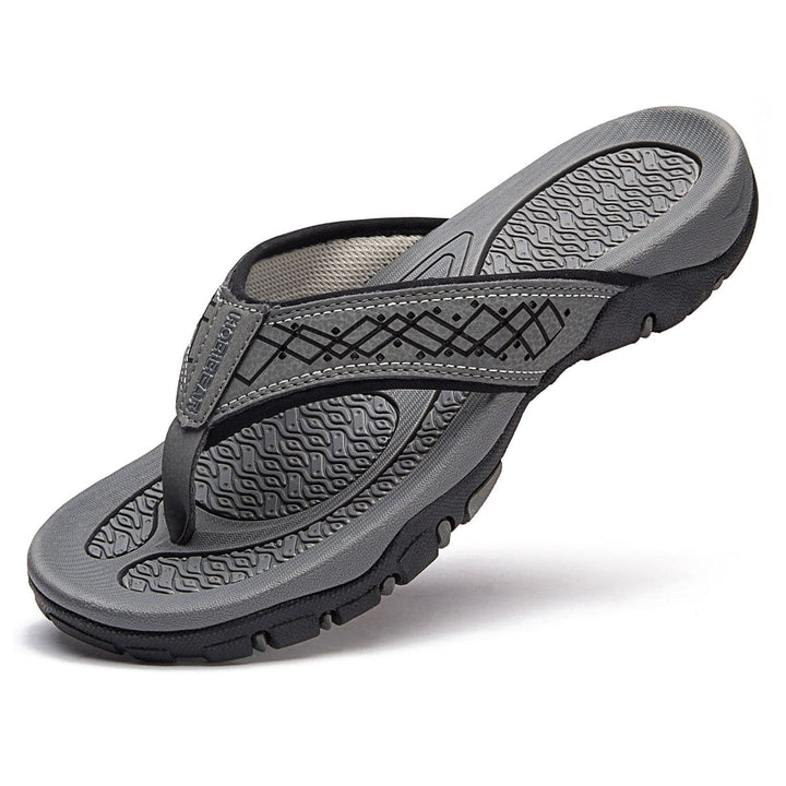 Bovenaanzicht van grijze herenslippers met orthopedische steun, casual en modieus.