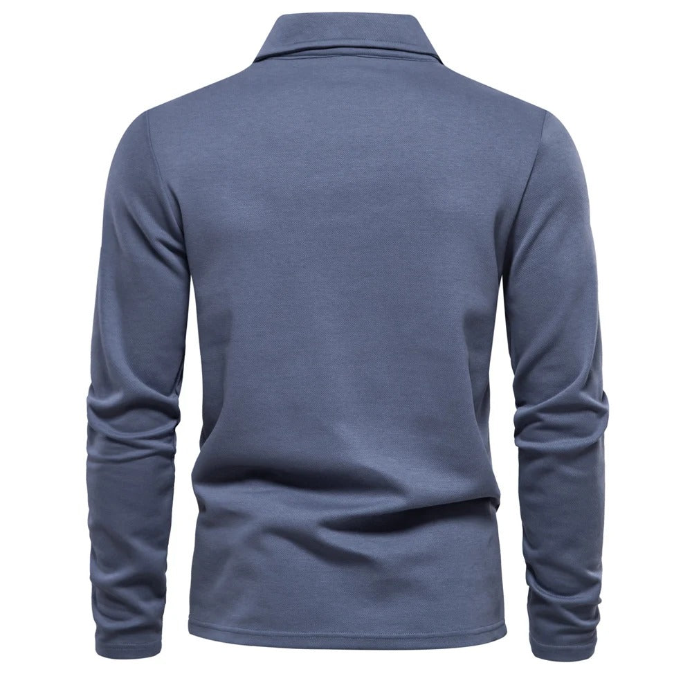 Model draagt een elegant heren poloshirt met lange mouwen, casual en comfortabel voor een tijdloze look.