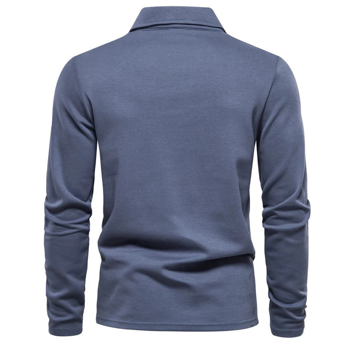 Model draagt een elegant heren poloshirt met lange mouwen, casual en comfortabel voor een tijdloze look.