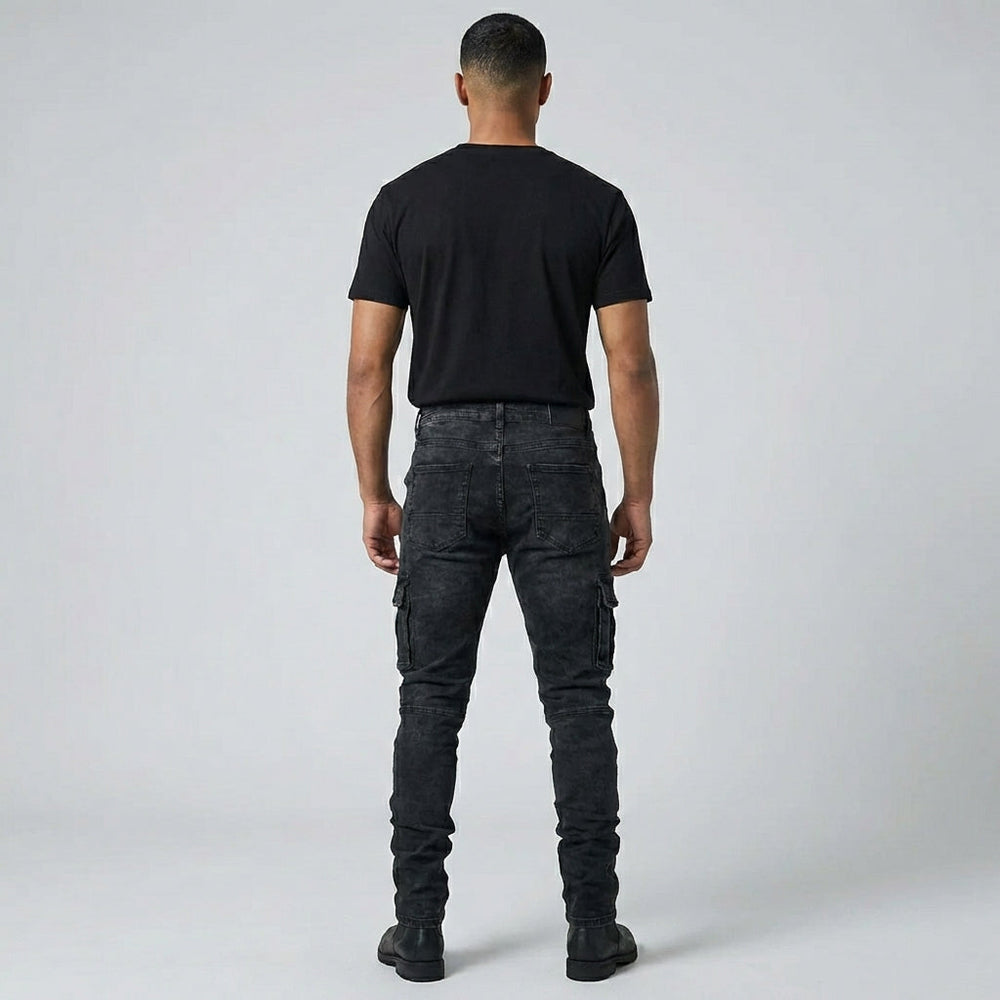 Model draagt casual heren stretch jeans, middenblauw, staand voor een stedelijke achtergrond, focus op comfort.