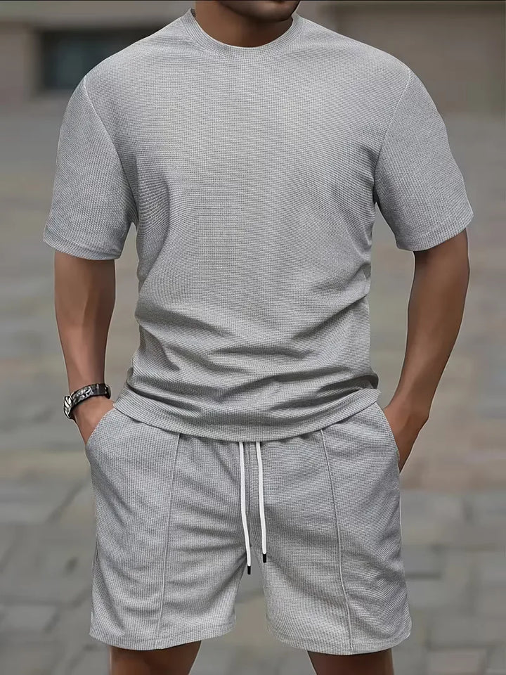 Heren strand kledingset: licht T-shirt en shorts, perfect voor een dagje aan zee.