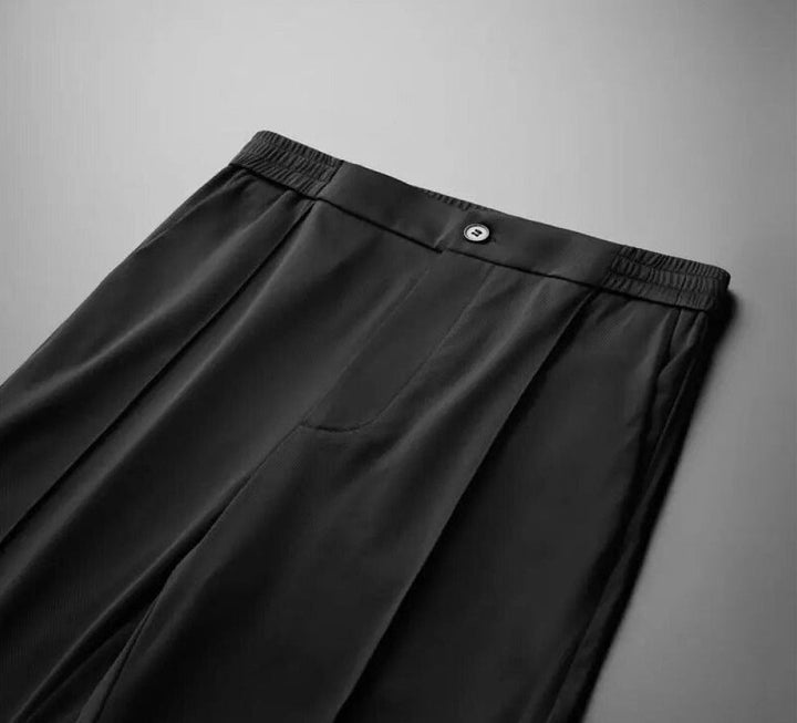 De volledige heren tweedelige set: poloshirt en pantalon, gepresenteerd op een effen achtergrond.
