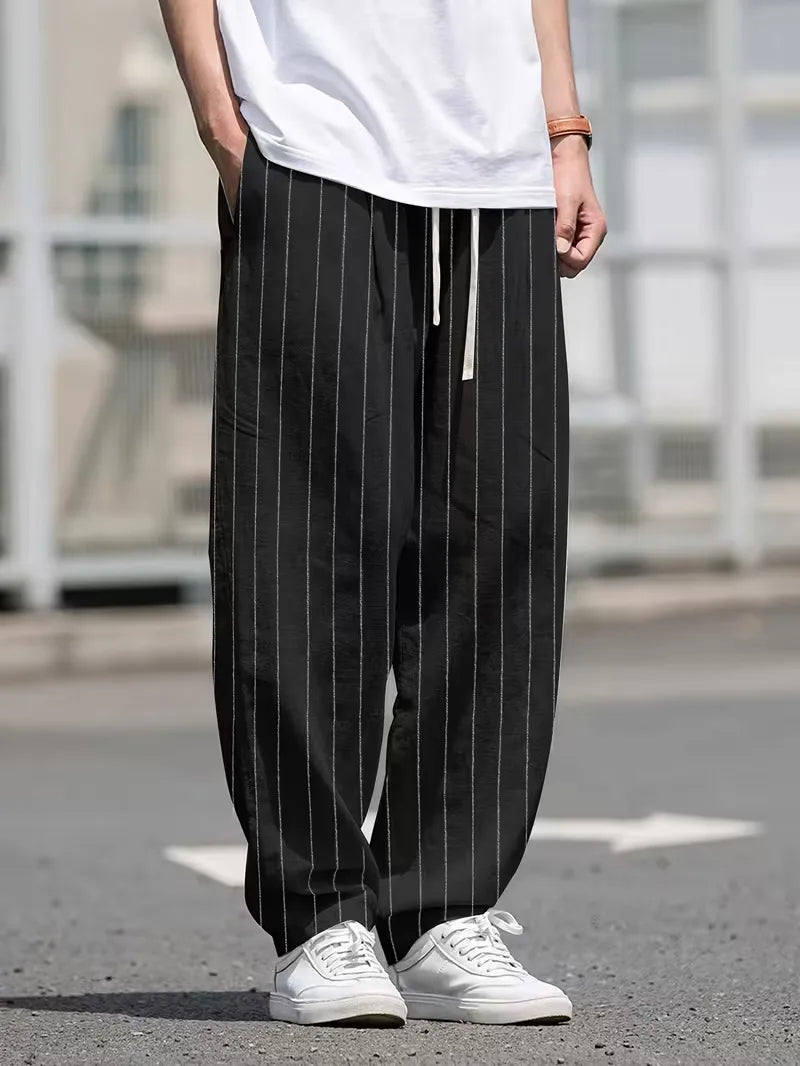 Trendy heren pantalon met verticale strepen en wijde pasvorm, in zwart, voor een moeiteloze stijl.