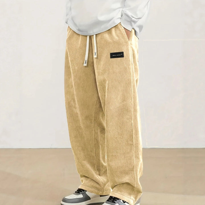 Model draagt comfortabele heren wijde jogger broek, ideaal voor een relaxte en moderne streetwear look.