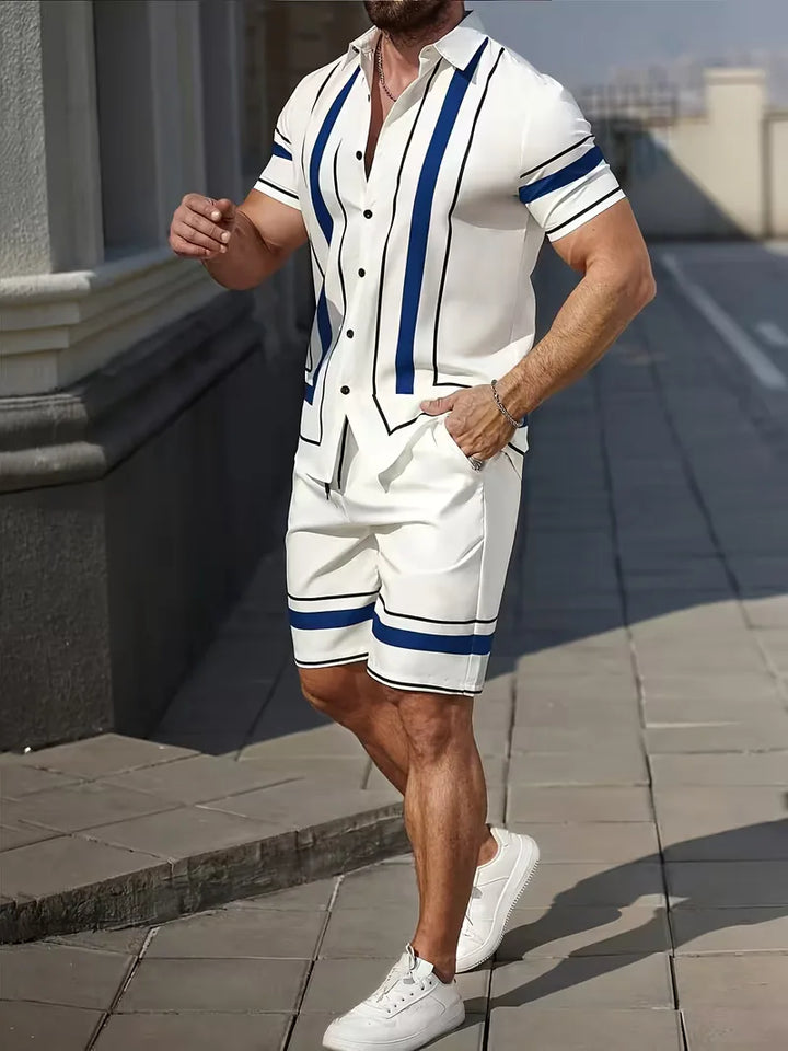 Man draagt zomerse tweedelige kledingset met trendy geometrische print. Wit-blauwe outfit, perfect voor strand, comfortabel en stijlvol.