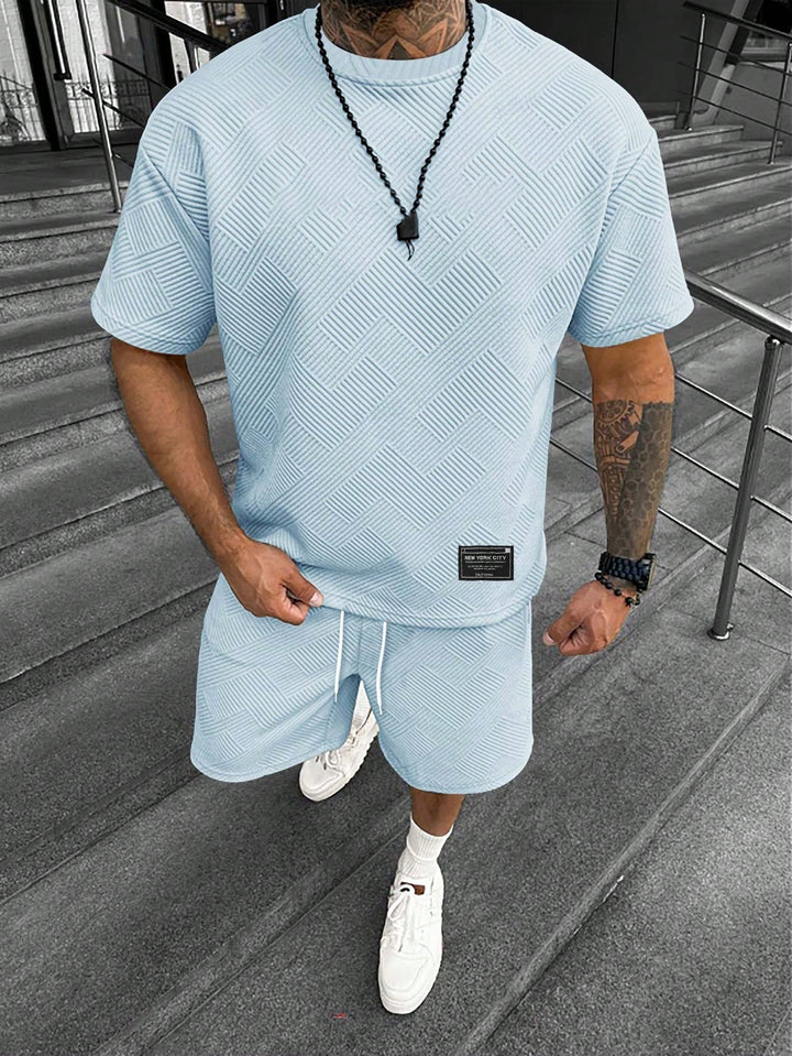 Ademende heren zomerset: zachte shorts en oversized T-shirt. Ideaal voor warme zomerdagen en strandkleding.