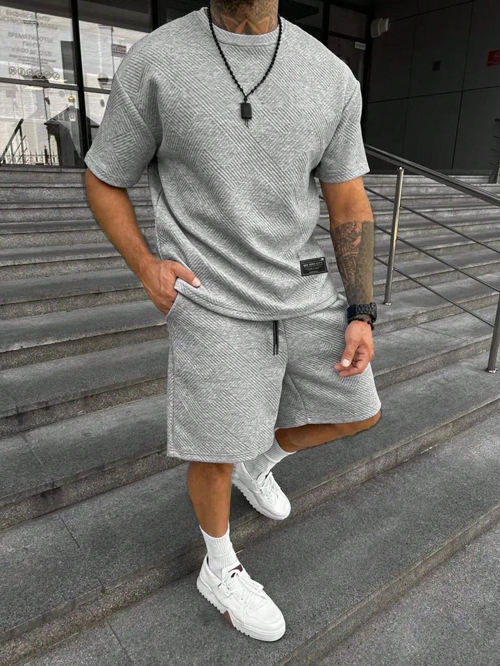 Ontspannen man in casual heren zomerset: comfortabele shorts en oversized T-shirt voor vrije tijd. Joggingpak.