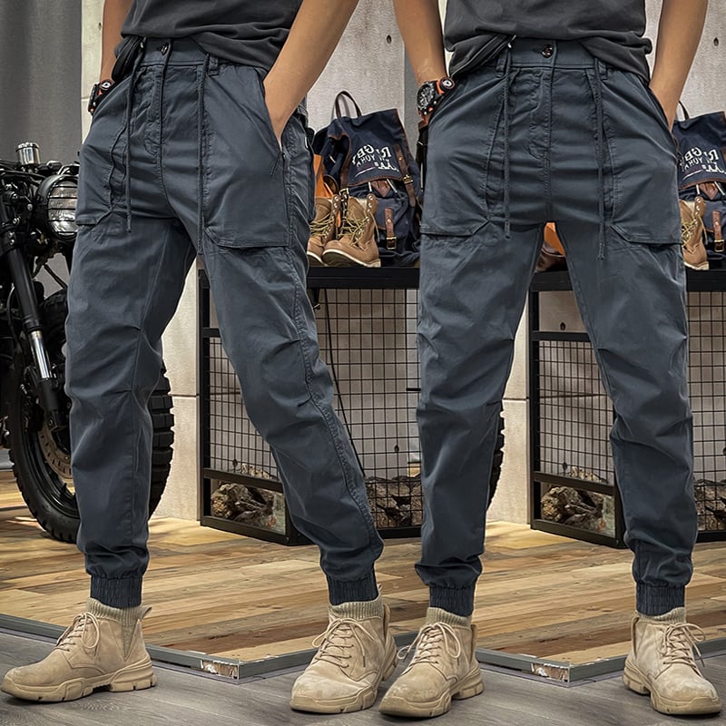 Donkerblauwe heren cargobroek, rechte pijpen en functionele zakken; comfortabele mannenmode voor zomerse casual look.