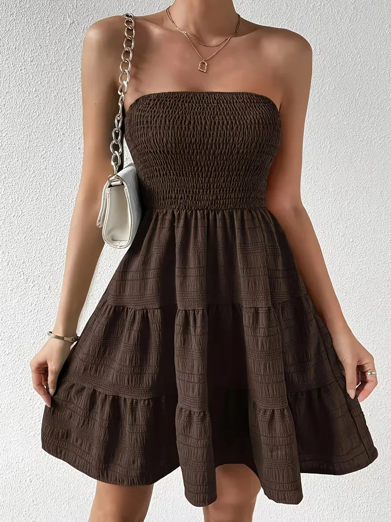 Vrouwelijke strapless A-lijn jurk in koffiebruin, met gelaagde rok, getoond op model voor zomerstijl.