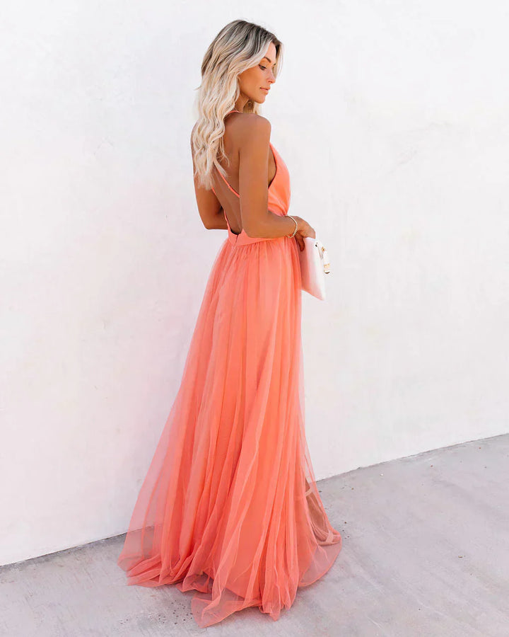 "Lange Amelia maxijurk in apricot, elegant met vloeiende lijnen en lichte stof, ideaal voor dagelijks en formeel gebruik."