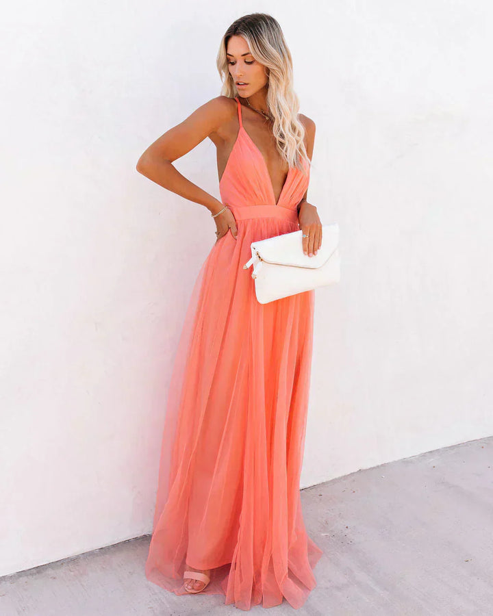 "Lange Amelia maxijurk in apricot, elegant met vloeiende lijnen en lichte stof, ideaal voor dagelijks en formeel gebruik."