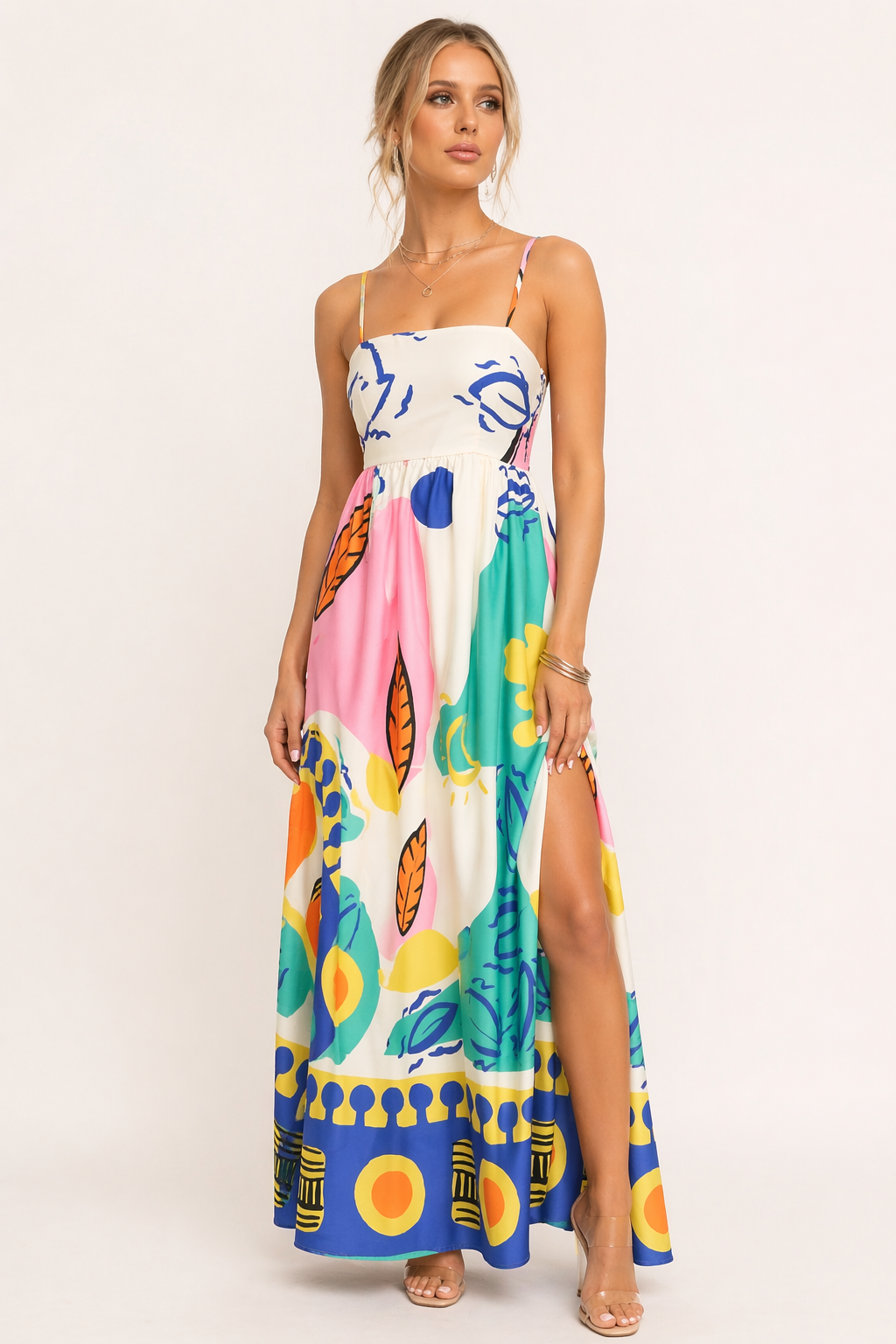 Lange witte dames zomerjurk met grafische print en elegante zijsplit, perfect voor vakantie.