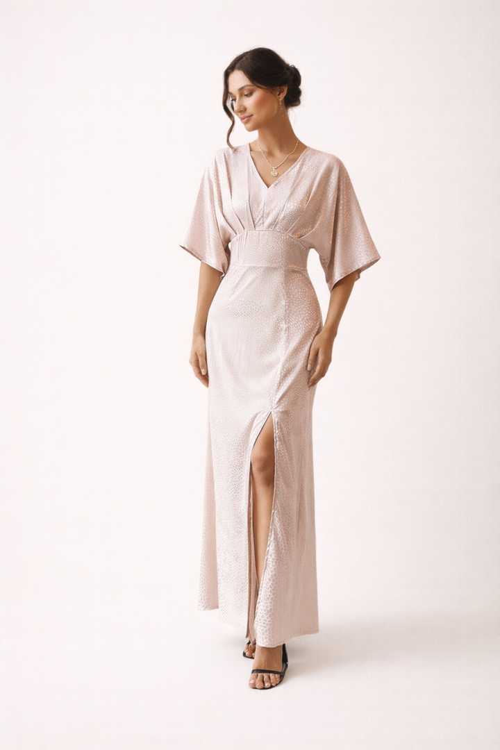 Lichtroze dames maxi jurk met korte mouwen en zijsplit. Luchtig en comfortabel voor een casual zomerlook.