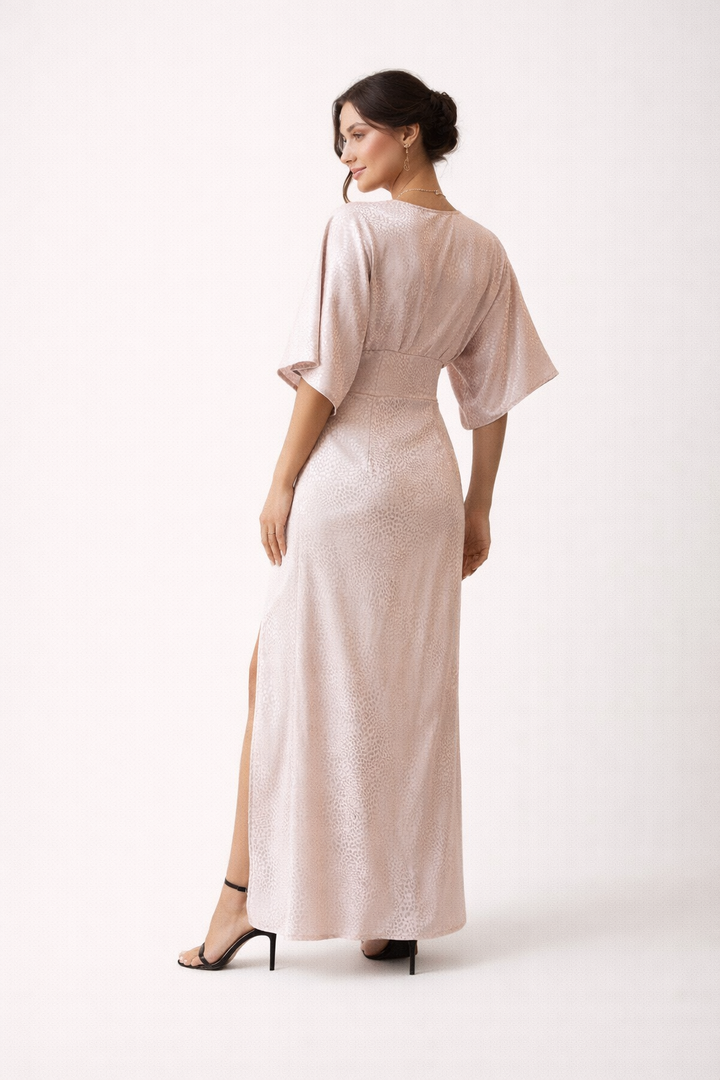 Modieuze lichtroze maxi jurk voor dames. Comfortabele zomerjurk met korte mouwen en elegante zijsplit.