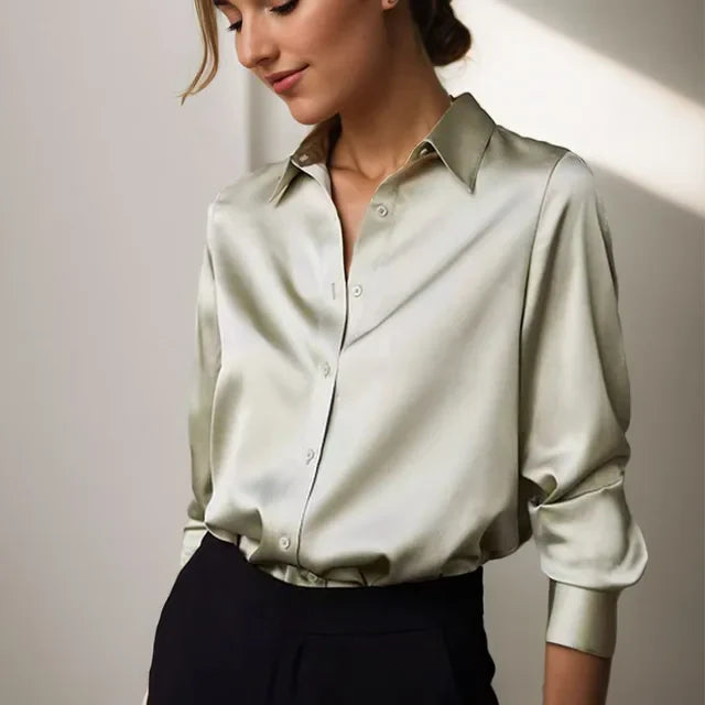 Celeste satijnen blouse dames, vloeiende stof, lange mouwen, subtiele glans, elegante kraag, verfijnde stijl.