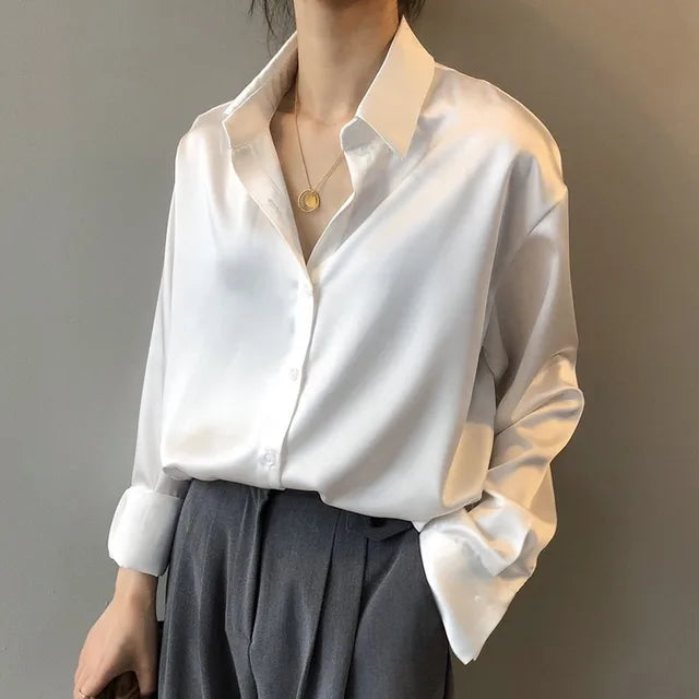 Celeste satijnen blouse dames, vloeiende stof, lange mouwen, subtiele glans, elegante kraag, verfijnde stijl.