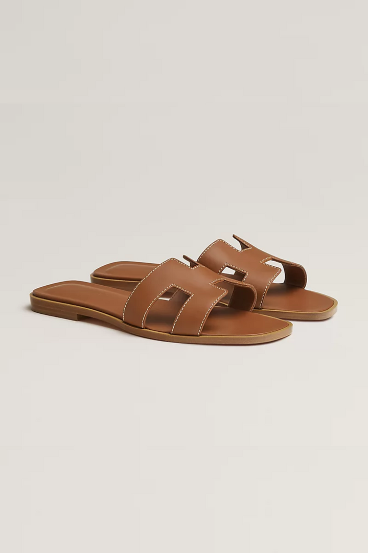 Stijlvolle dames teenslippers, luxe afwerking, comfortabele platte zool voor zomerse elegantie.