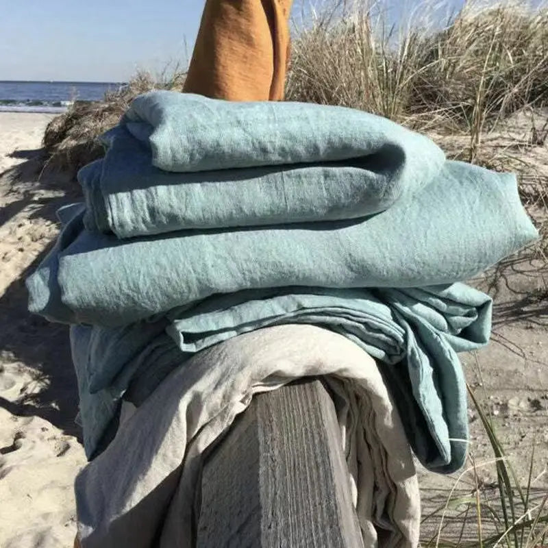 "Luxe linnen beddengoed, elegant en zacht, in diverse kleuren zoals abrikoos en donkergrijs. Perfect voor stijlvol comfort."