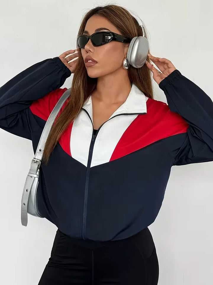 Marineblauw dames track jacket met trendy kleurblok design, ideaal voor sport of casual streetwear looks.