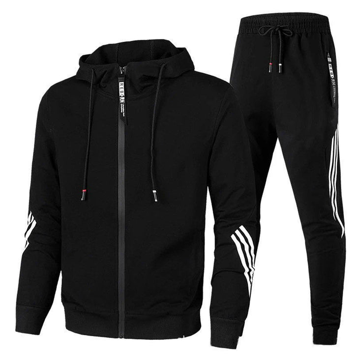 Man draagt grijs heren tracksuit. Comfortabel joggingpak met hoodie en broek, ideaal voor outdoor en ontspanning.