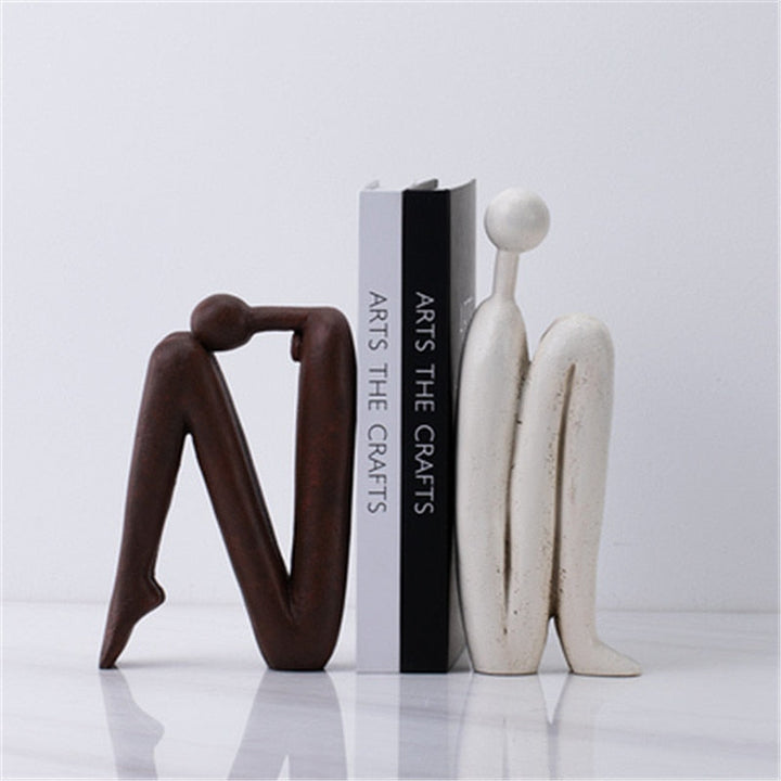 Moderne decoratieve boeksteun van wit metaal, ideaal voor stijlvolle boekenplank organisatie in elk interieur.