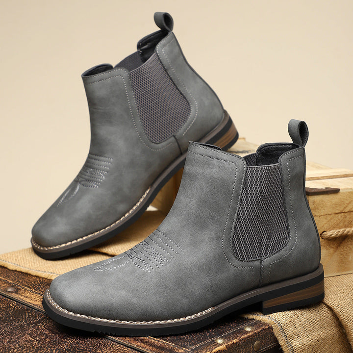 Stijlvolle heren instaplaarzen: zwarte Chelsea boots met subtiele western details voor modieuze mannen.