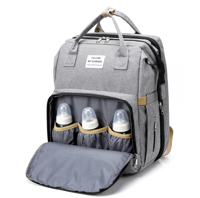 Open multifunctionele luiertas rugzak toont ruim interieur en comfortabel opvouwbaar babybed.